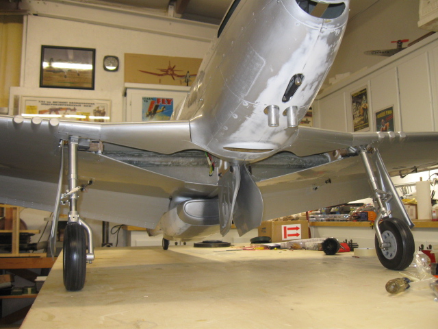 Here is the P-51 on the gear, but still in need of a paint scheme. Of course, the inner doors remain closed if air pressure is present, using the Ultra Precision 2 air control valve. But, between flights, it looks cool to bleed the air off the tank and drop them down as on the full-scale P-51 when parked. Once you have done the scale doors successfully, you won’t have near the trouble the next time out. There is a learning curve for sure, but the same principles apply to installing the inner and outer gear doors on most Warbirds. 